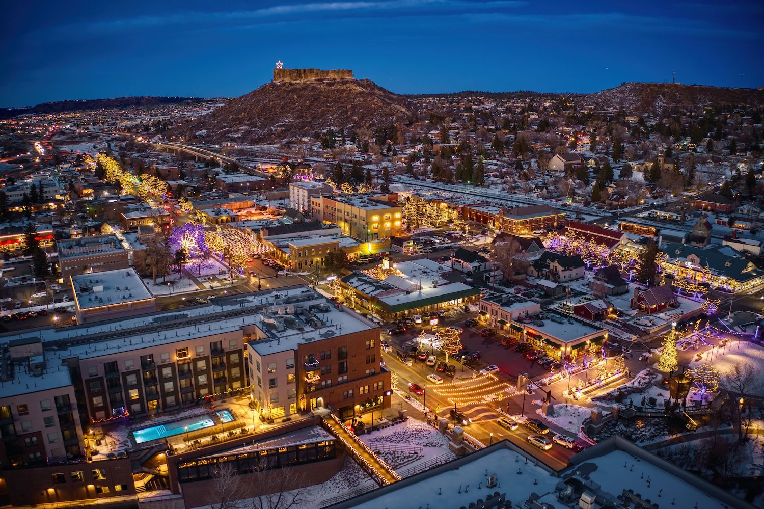 Downtown Castle Rock illuminated at dusk beneath its namesake rock